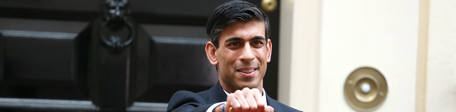 Rishi Sunak stands outside 11 Downing Street holding a red box on Budget Day