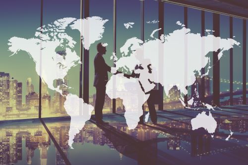 A global backdrop as two people shake hands