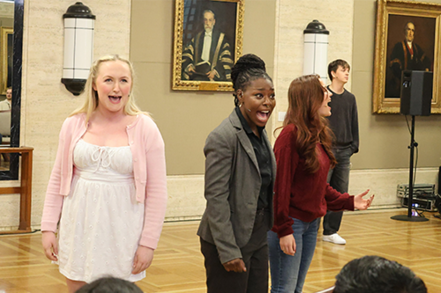 Three performers sing emotionally and loudly
