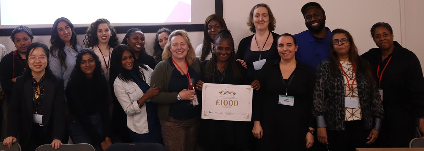 A group of people pose for a photo, one holds a certificate 