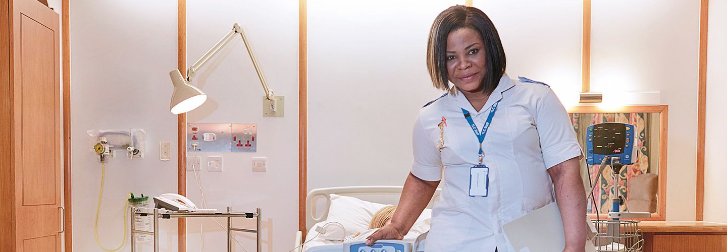 Woman standing in-front of a hospital bed