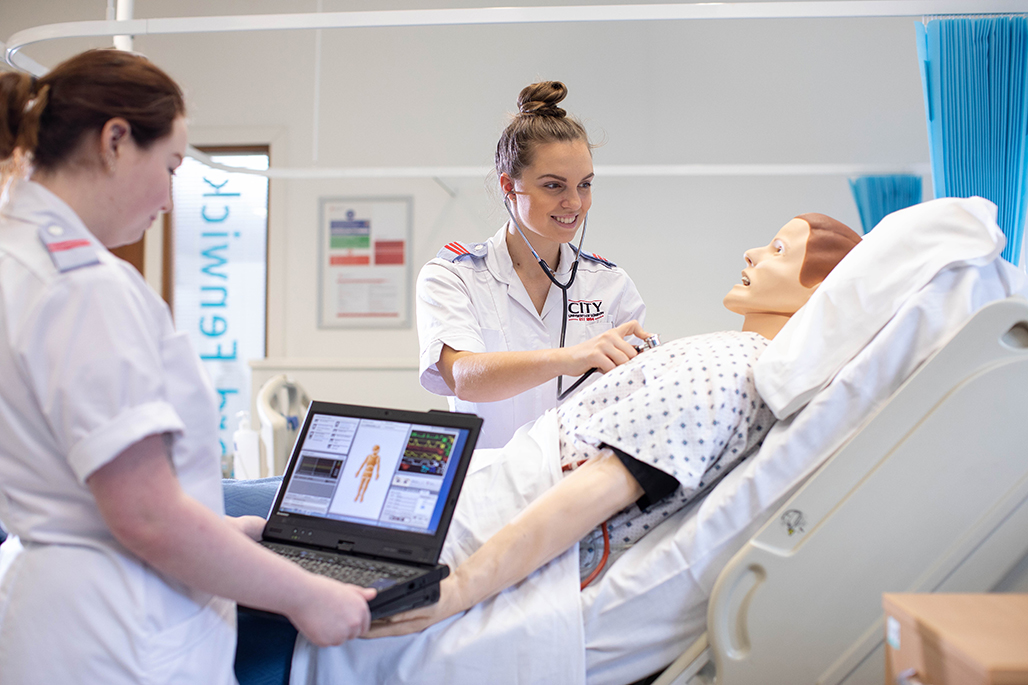 Two female students in training ward using patient dummies