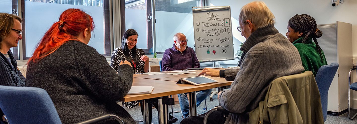 Academic and students around a table talking