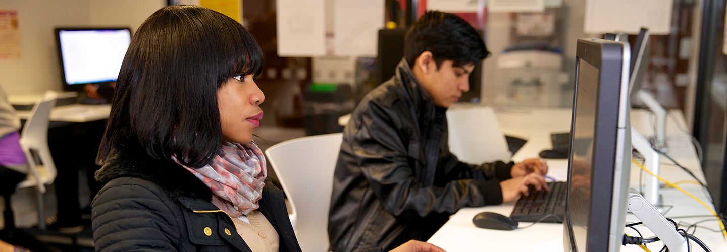 Female student looking at a computer screen in the computer lab