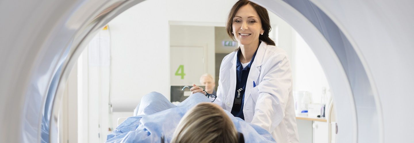 Patient being entered into an MRI brain scanner by a friendly doctor