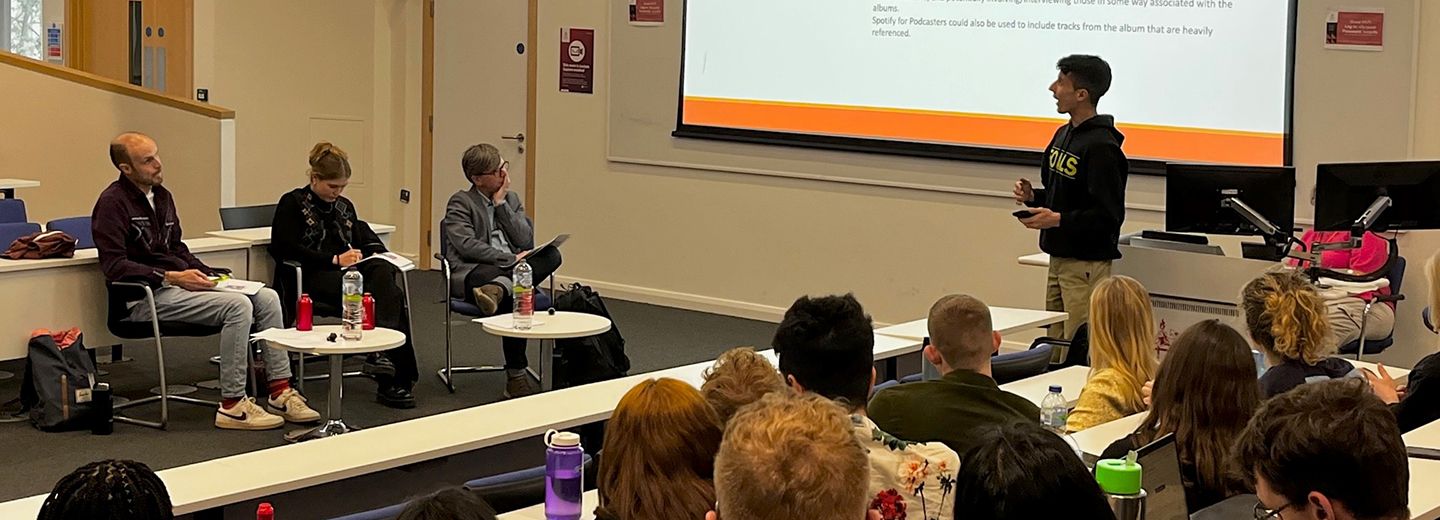 Student pitches a podcast idea to three panellists