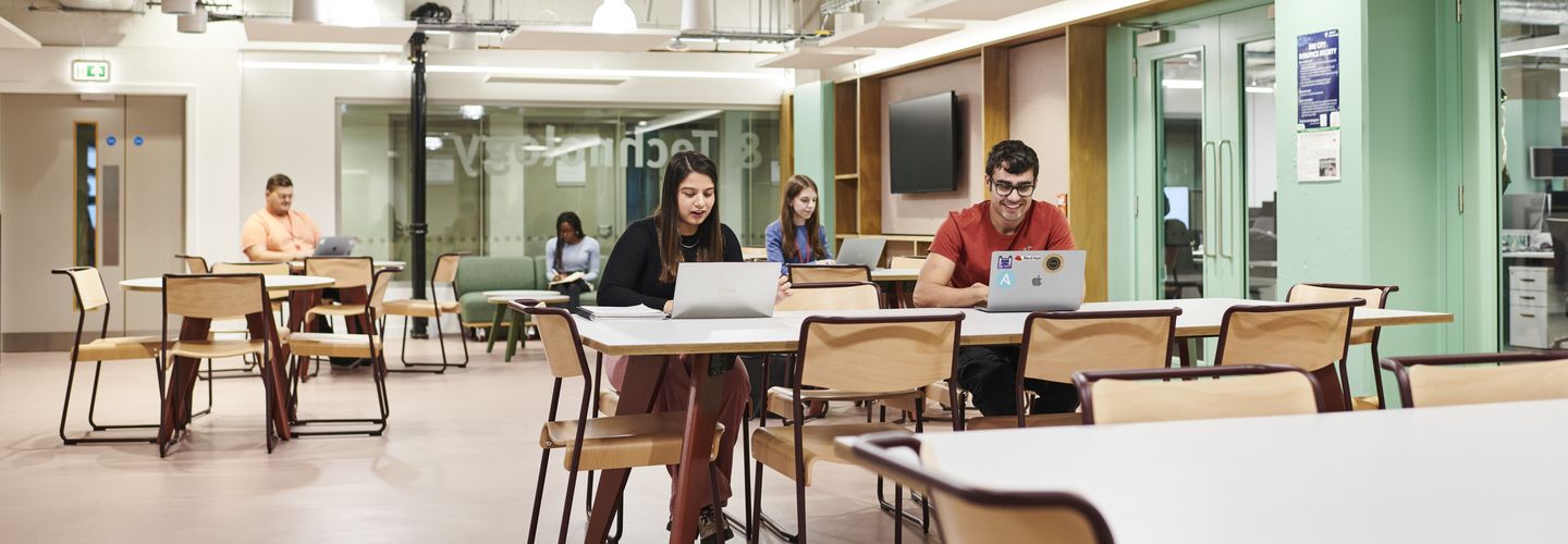 Students studying at high tables in School of Science & Technology facilities.