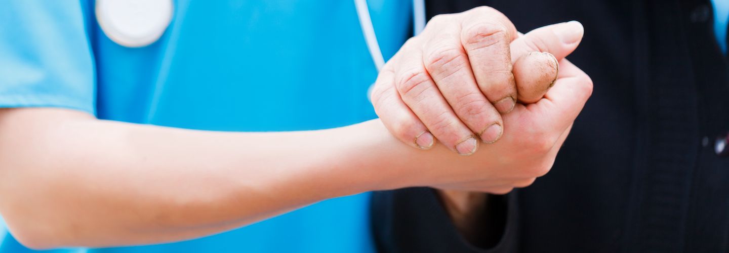 A nurse holding an eldery lady's hand with care