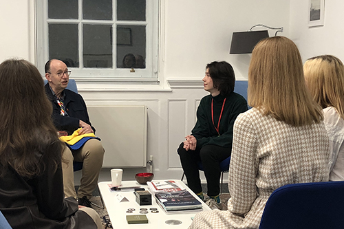 Professor Anthony Finkelstein sitting and chatting in the President's Office with four Ukrainian Global University students