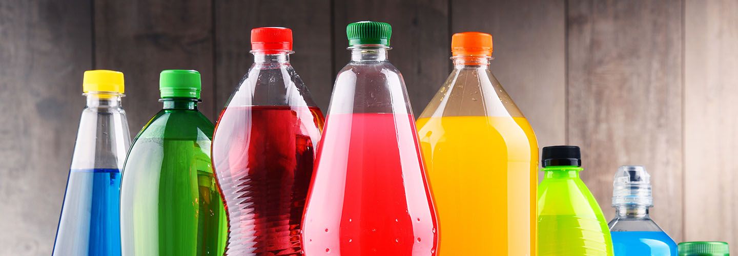 Sugary drinks bottles against a wooden wall