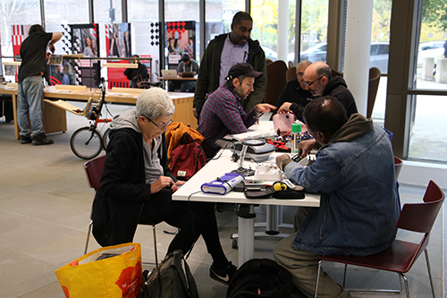 Group of people round a table in the Pavillion, working with electrical equiptment