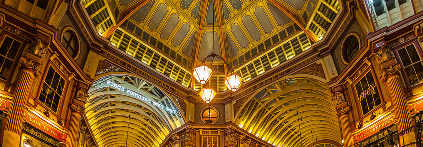 A gilded and brightly covered arches and ceiling of Leadenhall Market