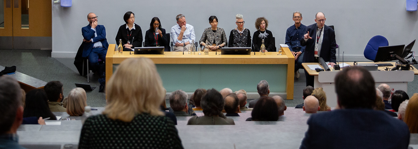 A group of people sitting at a panel in a lecture hall