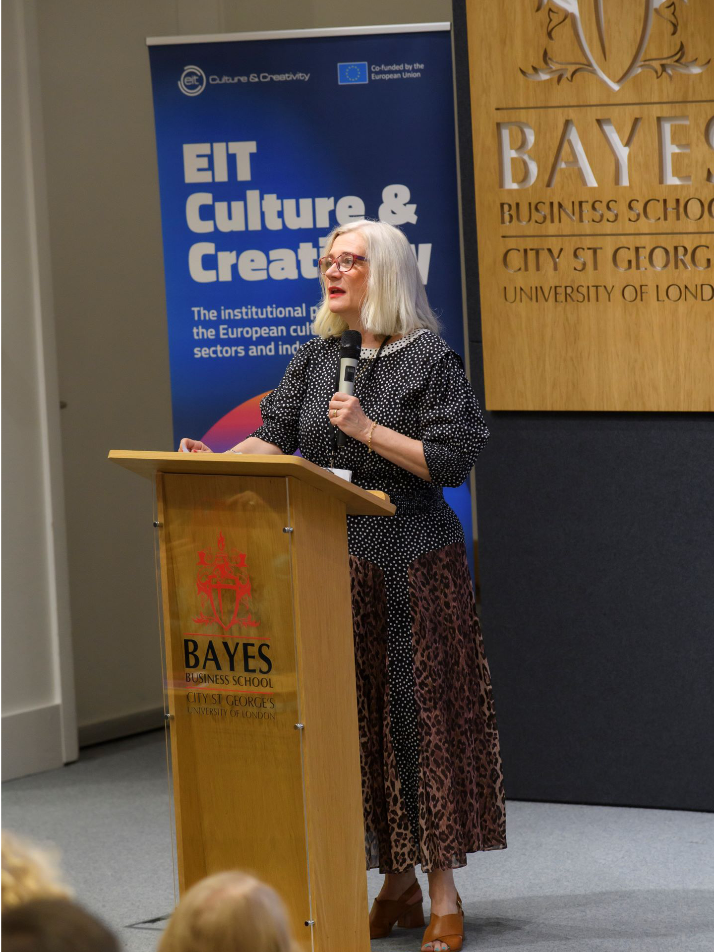 A white woman speaks at a lectern