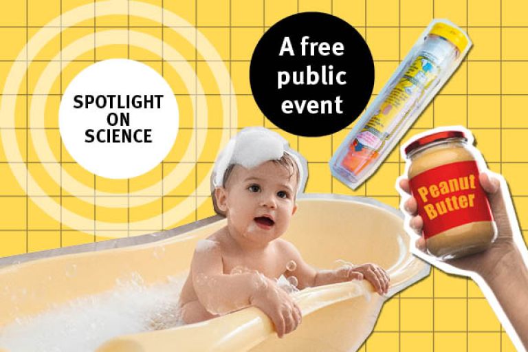 A baby sits in a bathtub surrounded by a bottle of baby shampoo and a bottle of baby soap.