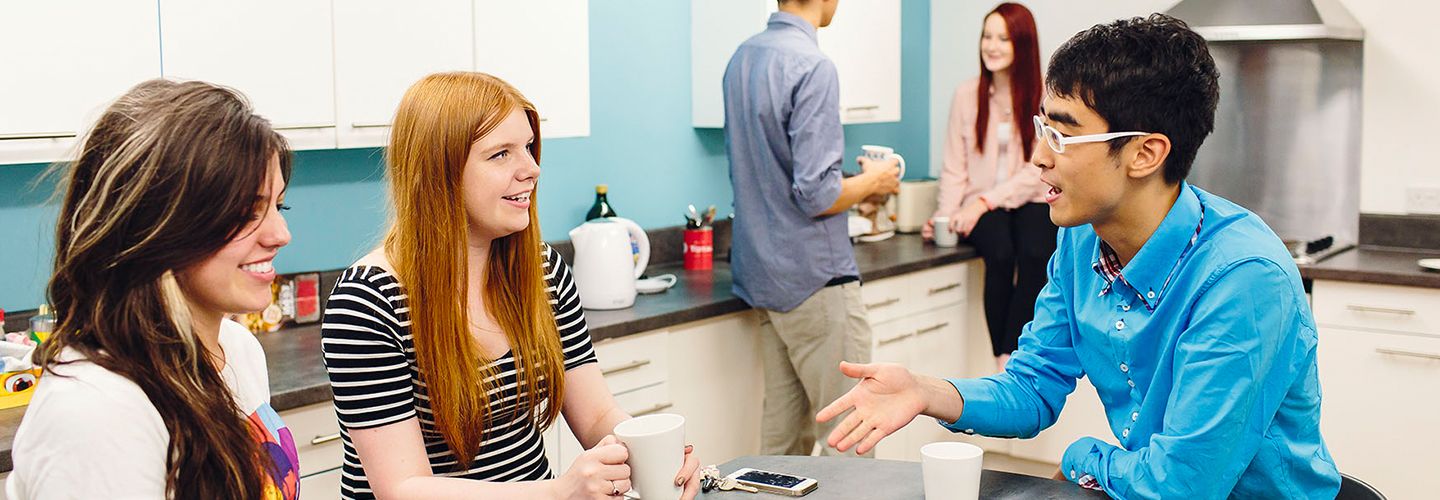 Students sitting at a table in a kitchen