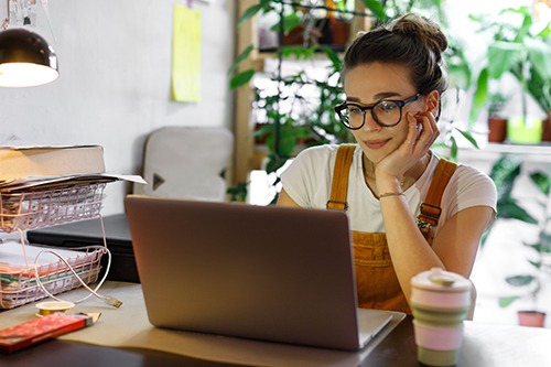 Woman working from home looking at a laptop screen