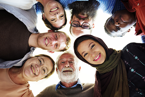A group of people with different backgrounds and ethnicities smile together