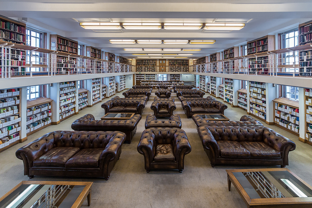 Chesterfield sofas in the middle of the room surrounded by book shelves
