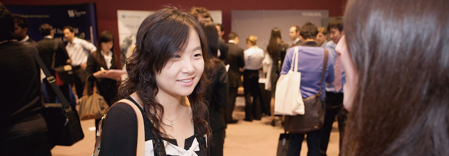 Female student at a career fair talking to a female recruiter 