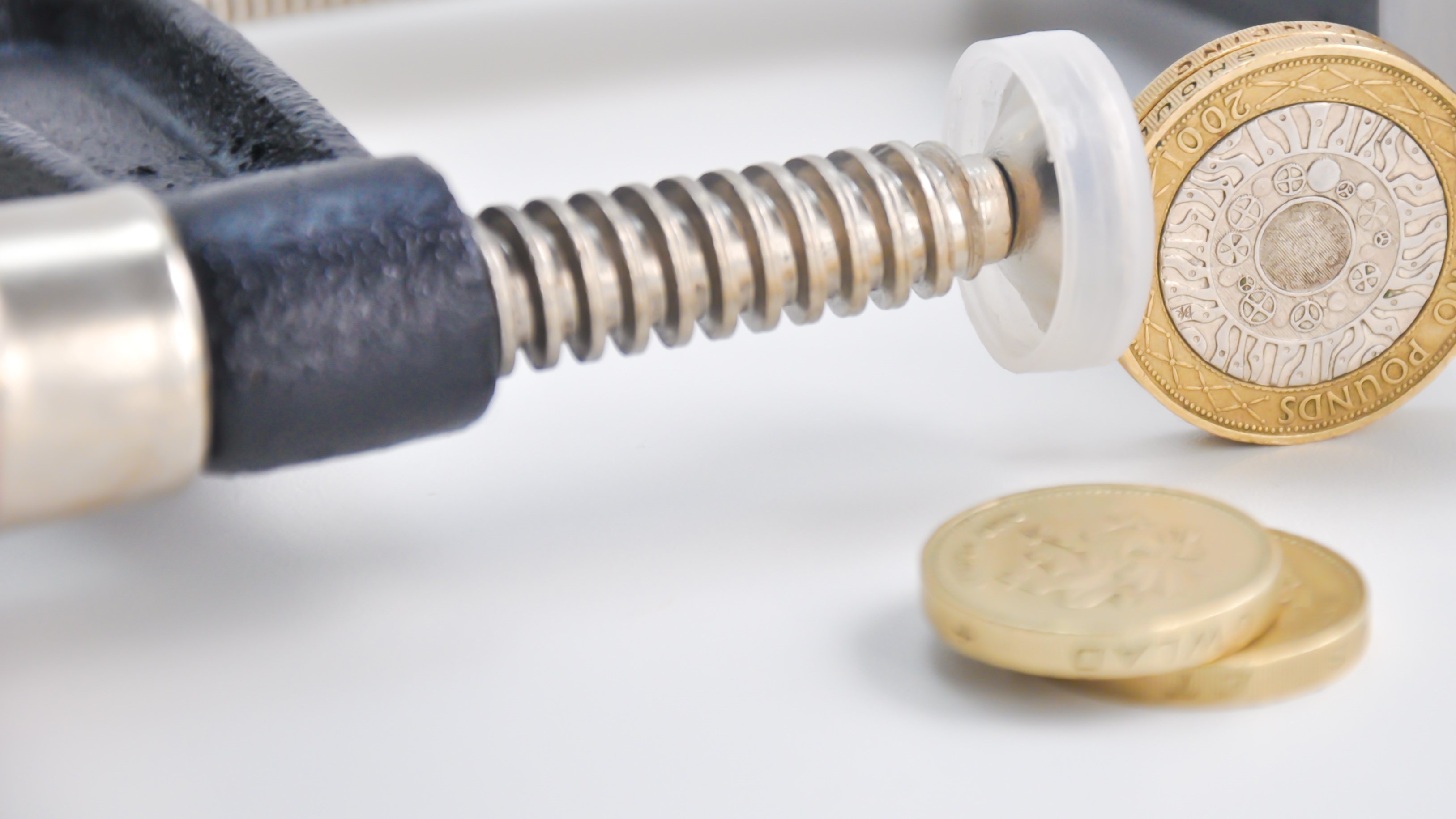 A pound coin is clamped