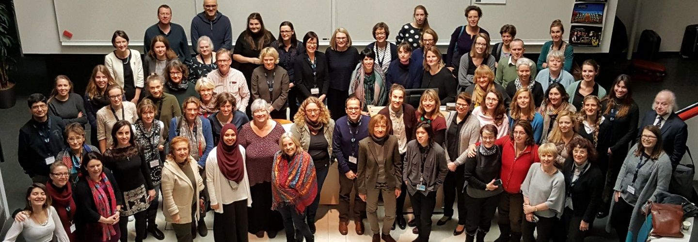 Collaboration of Aphasia Trialists (CATs) group photo of many international members looking up at the camera from a lower level