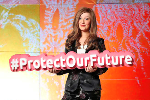 A young woman holds a sign