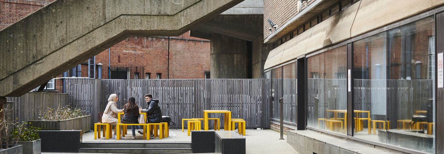 A group of students sitting and chatting outside the Drysdale Building.