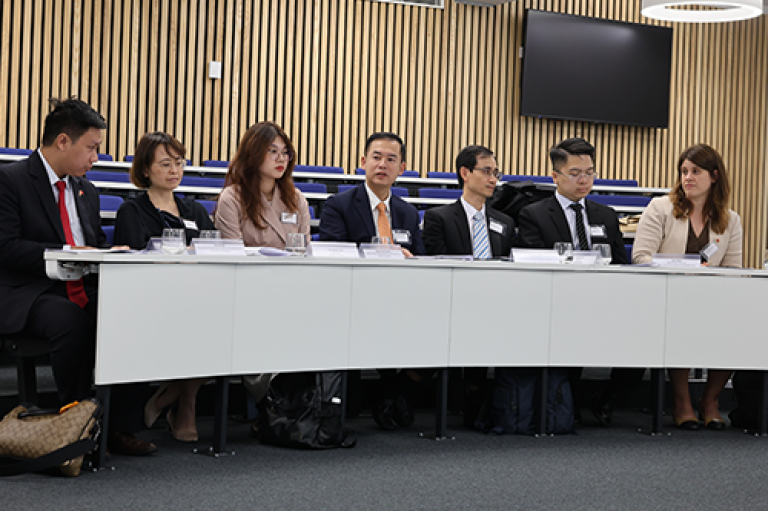 A group of professionals sit in a row at an event