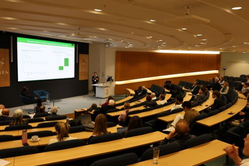 A woman speaking at a lectern as people listen