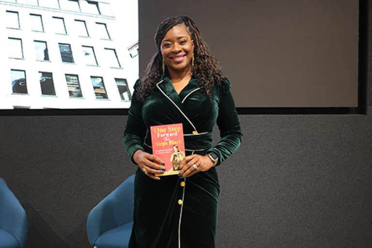 A woman holds a book and poses