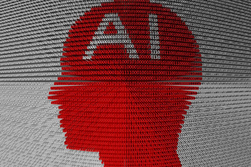 Binary code - ones and zeros - arranged in the shape of a face with the letters A and I emblazoned across the forehead.