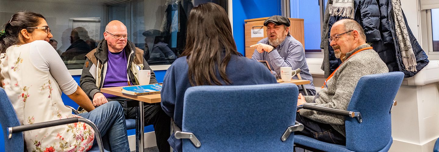 Staff and participants discussing around a table