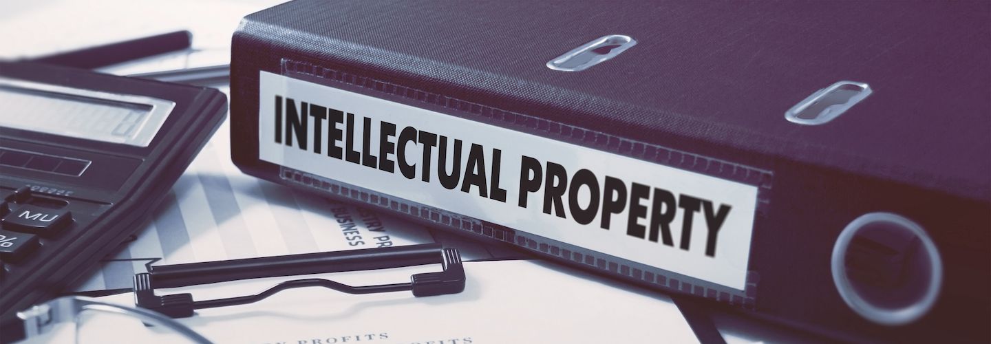 Office folder with inscription Intellectual Property on office desktop with office supplies