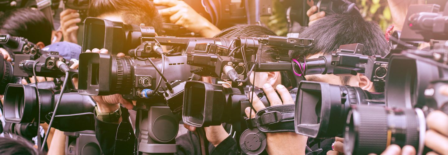 A large number of press and media reporters with their cameras at a broadcasting event