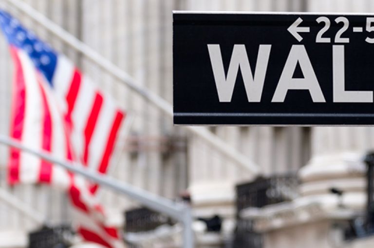 Wall Street sign with American flag in background