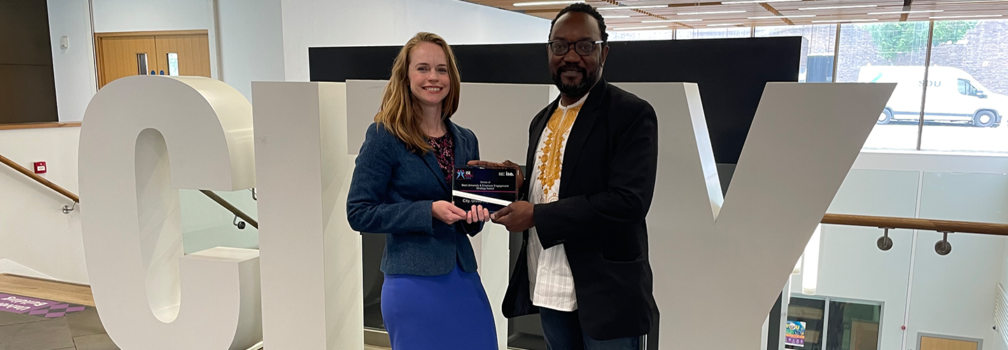 A woman accepts an award from a man