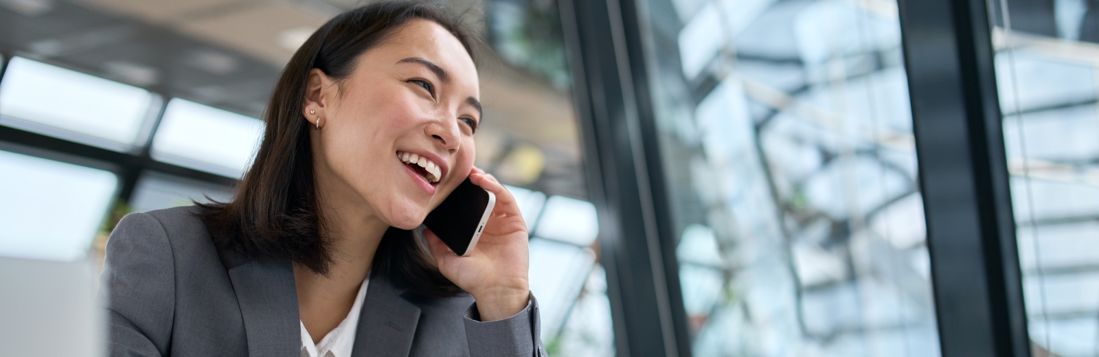 A woman in a suit laughs on the phone