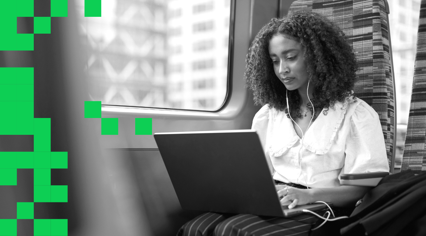 Woman working on a laptop on a train.
