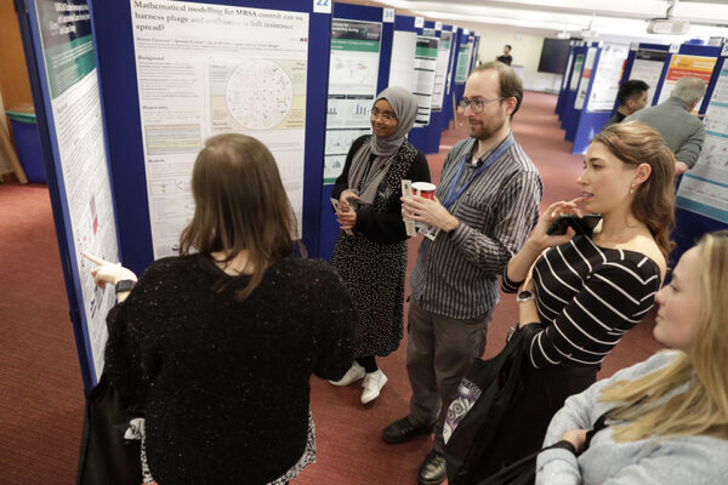 Researchers stood around poster in board room
