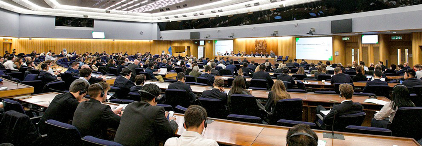 People sit in an auditorium with a view of screens