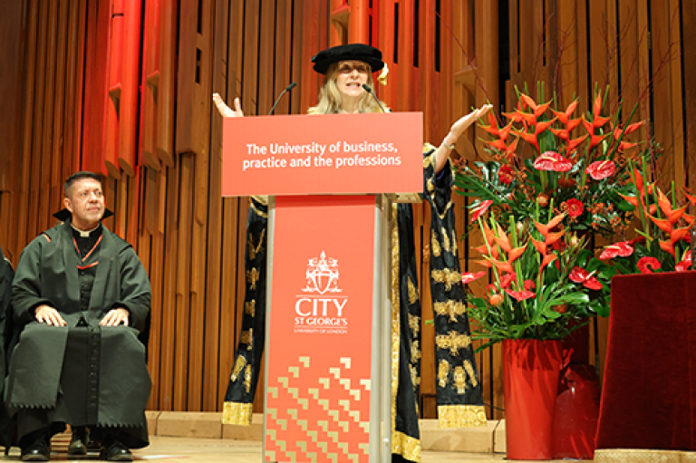 A woman gives a speech at a podium 