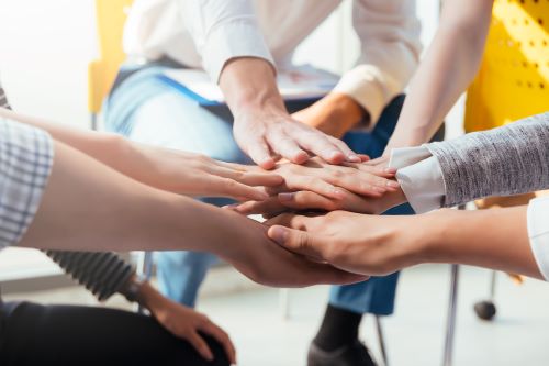 A group of hands clasp each other