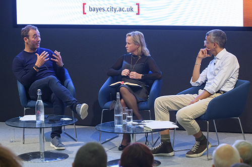 Professor Jane Martinson on the stage speaking with Kamal Ahmed and Sir William Lewis.