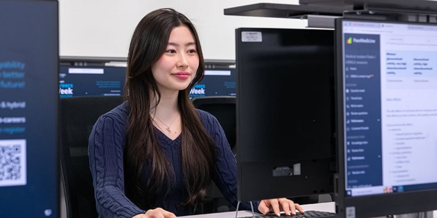 Student sat at desk using computer room