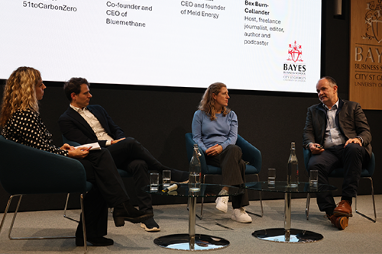 Four people speak to each other a panel 