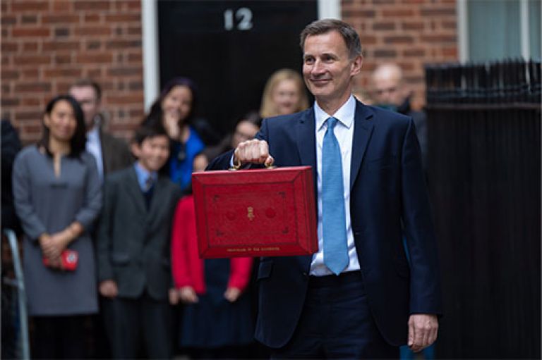 An image of Jeremy Hunt, Chancellor of the Exchequer, stands in front of Downing Street holding out the red box briefcase which holds the Spring Budget 2024. 