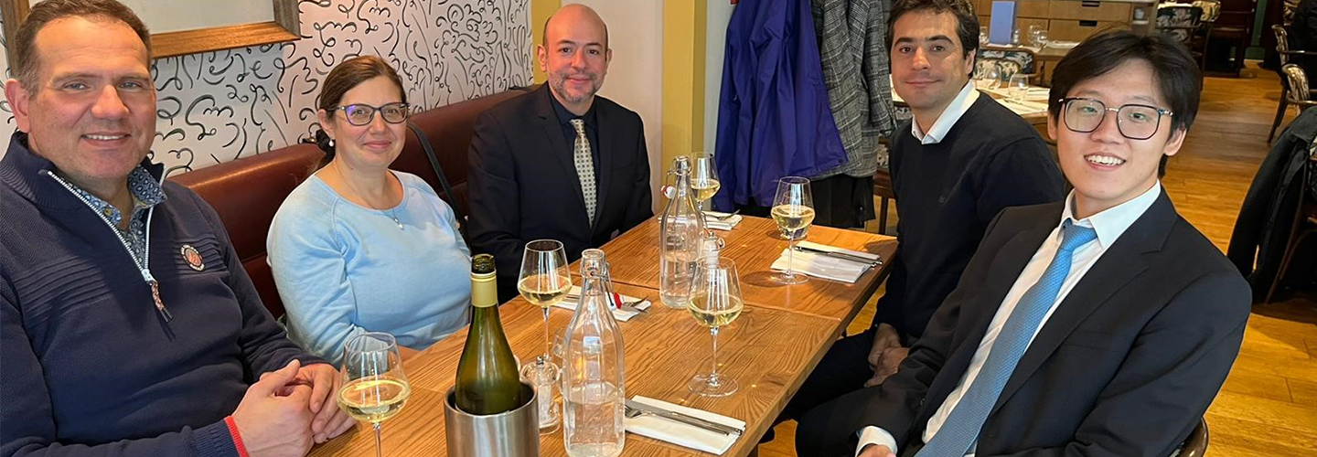 Five people sit at a table in a restaurant before eating