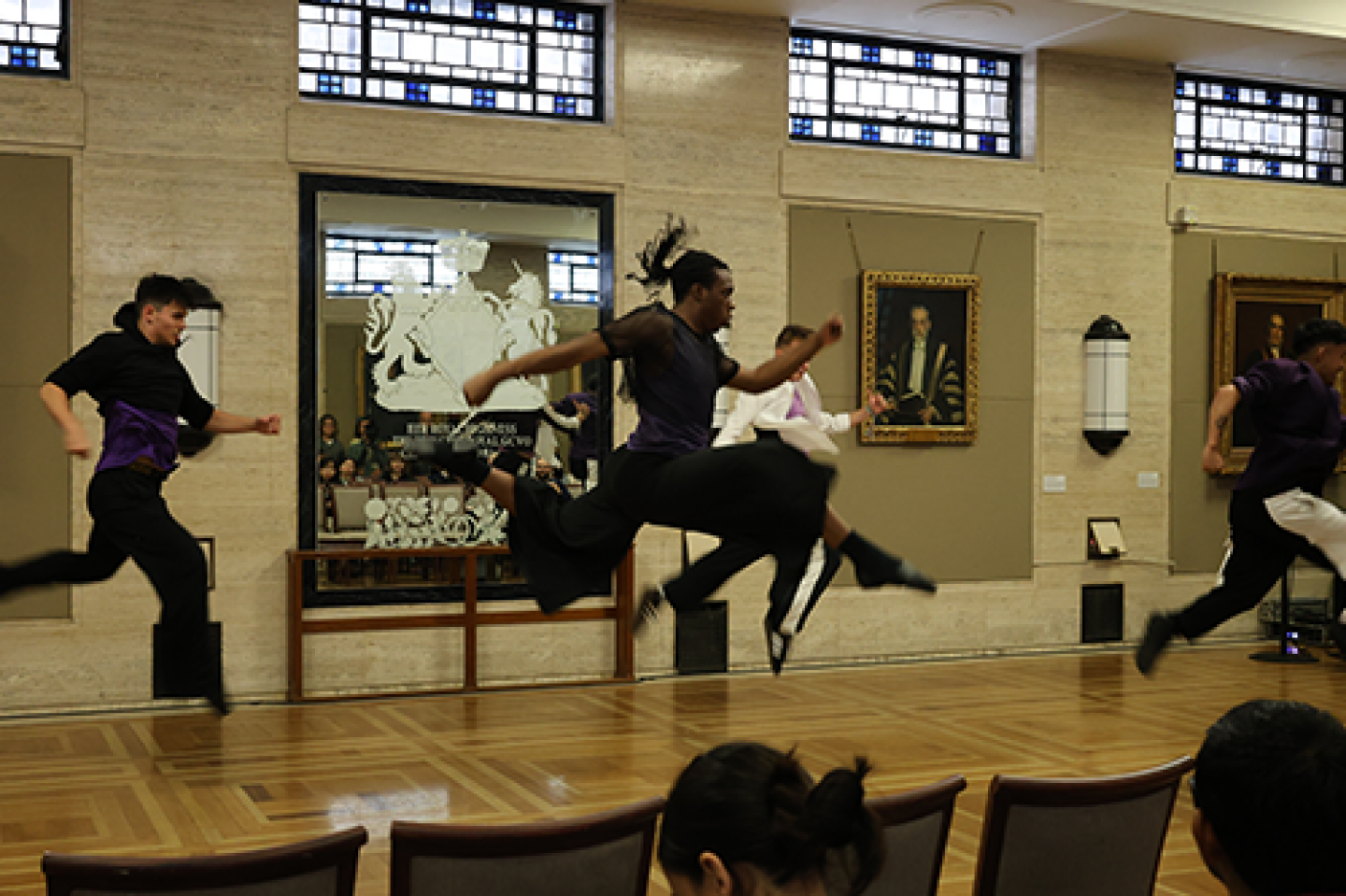 Dancers leap in the air during a dance performance