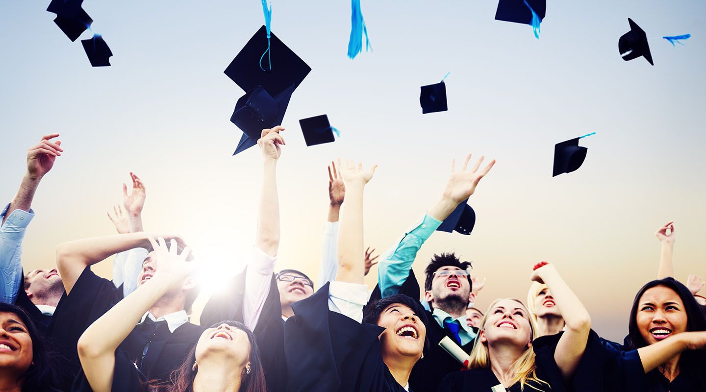Cheerful students throwing graduation caps in the Air Graduation caps